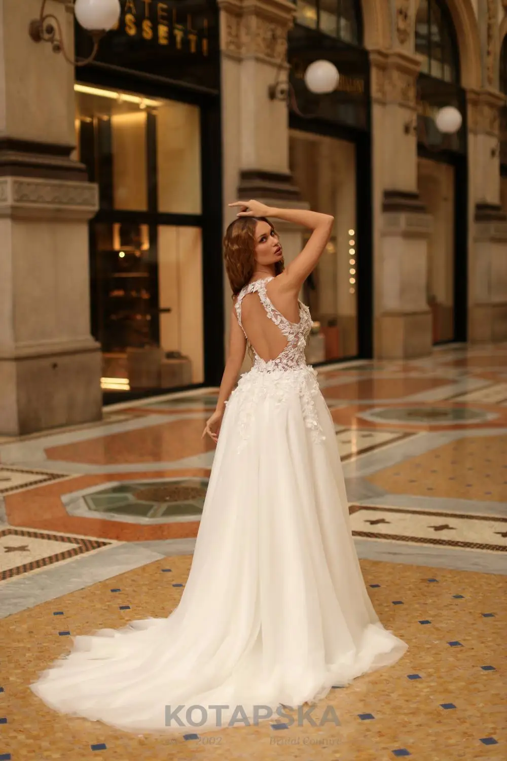 Braut in einem Hochzeitskleid mit 3D-Stoffblüten und Tüllrock, Rückenansicht
