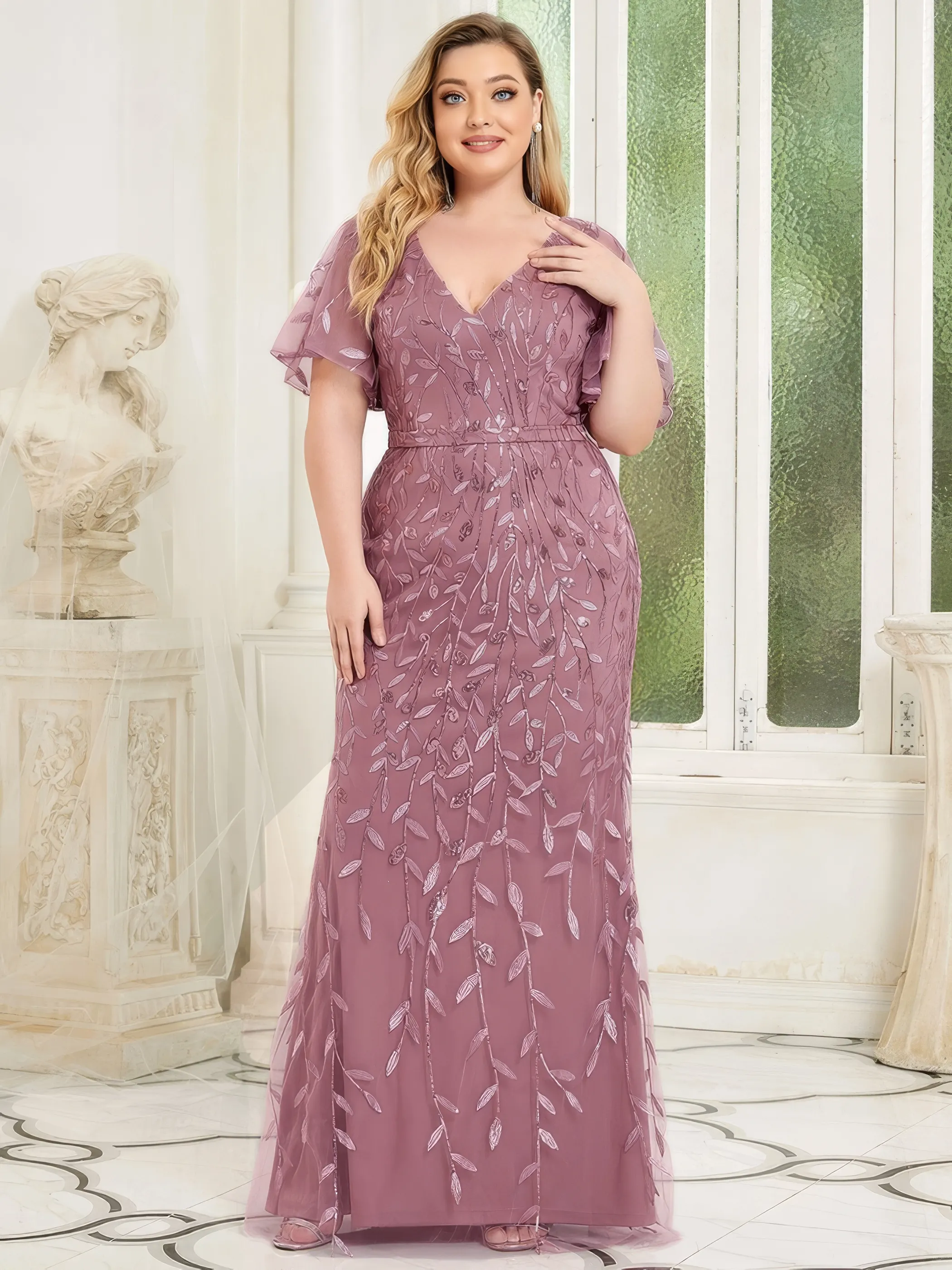 Frau in einem Abendkleid Altrosa mit Fledermausärmeln und Stickereien