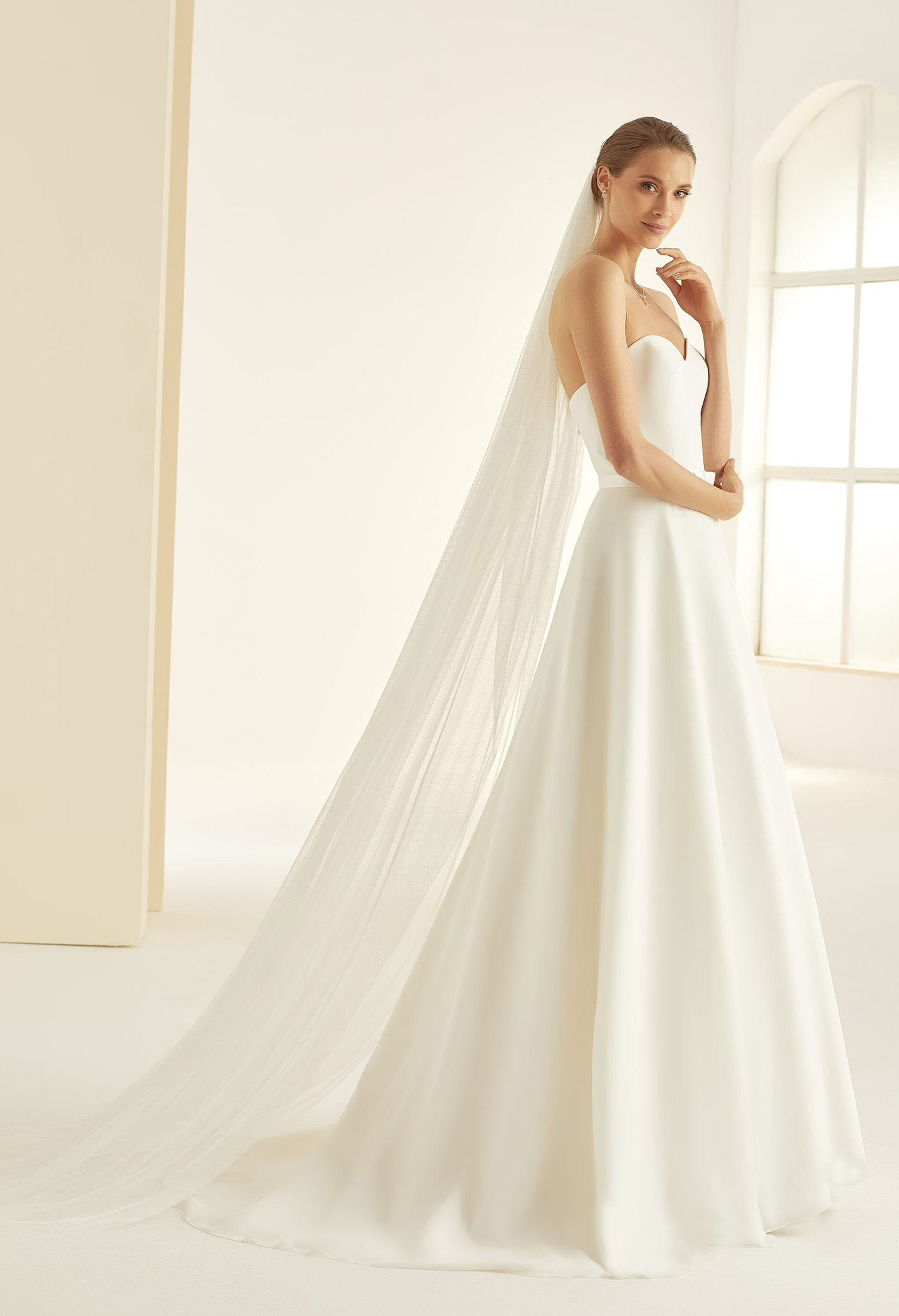 Glitzertüll-Schleier zu kaufen bei Samyra Fashion Zürich Braut in einem schlichten Brautkleid kombiniert mit einem langen Brautschleier aus Glitzertüll