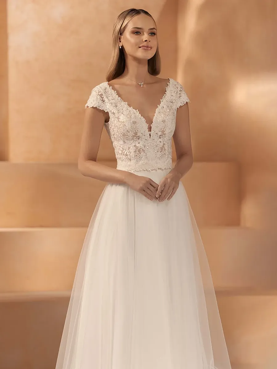 Braut in zweiteiligem Mix & Match Brautoutfit: florales Spitzen-Top mit kurzem Ärmel und tiefem V-Ausschnitt kombiniert mit weitem Tüllrock in Ivory – Mix & Match Brautmode Zürich bei Samyra Fashion