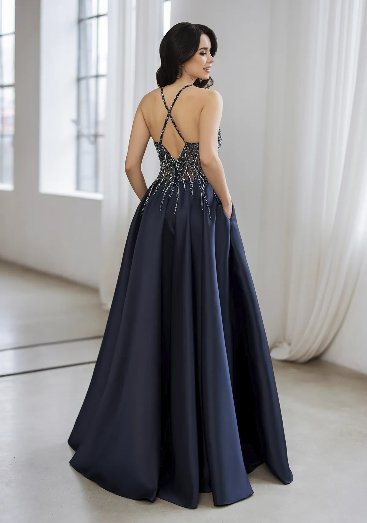 Ballkleid aus Satin in A-Linie dunkelblau, Rückenansicht Frau in einem dunkelblauen Ballkleid aus Satin in A-Linie, Rückenansicht