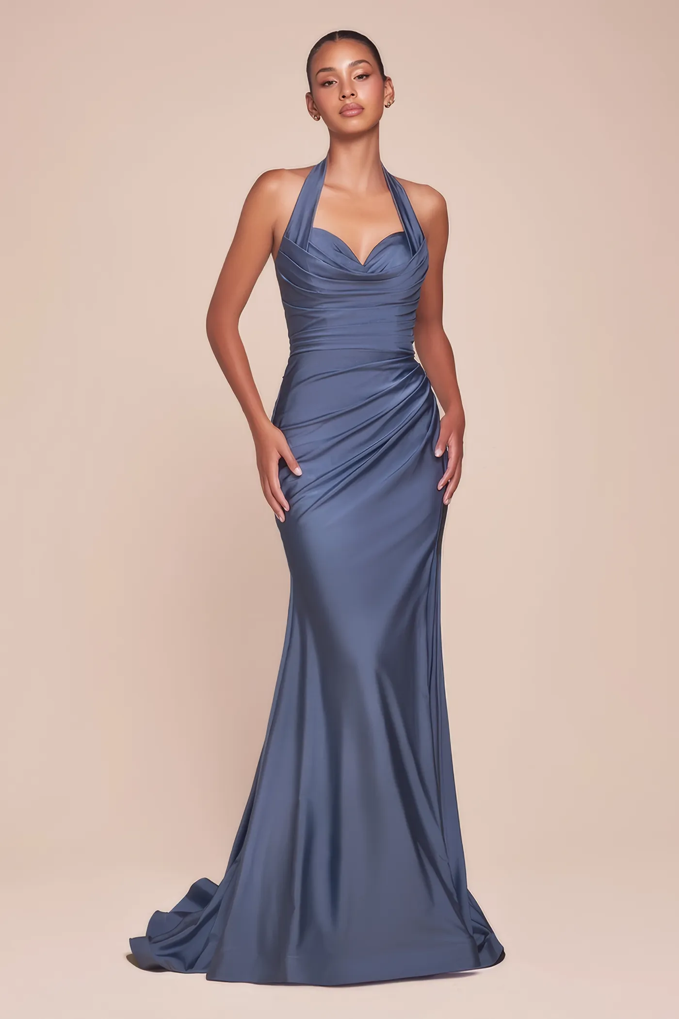 Frau in einem rauchblauen, figurbetonten Abendkleid mit hohem Beinschlitz