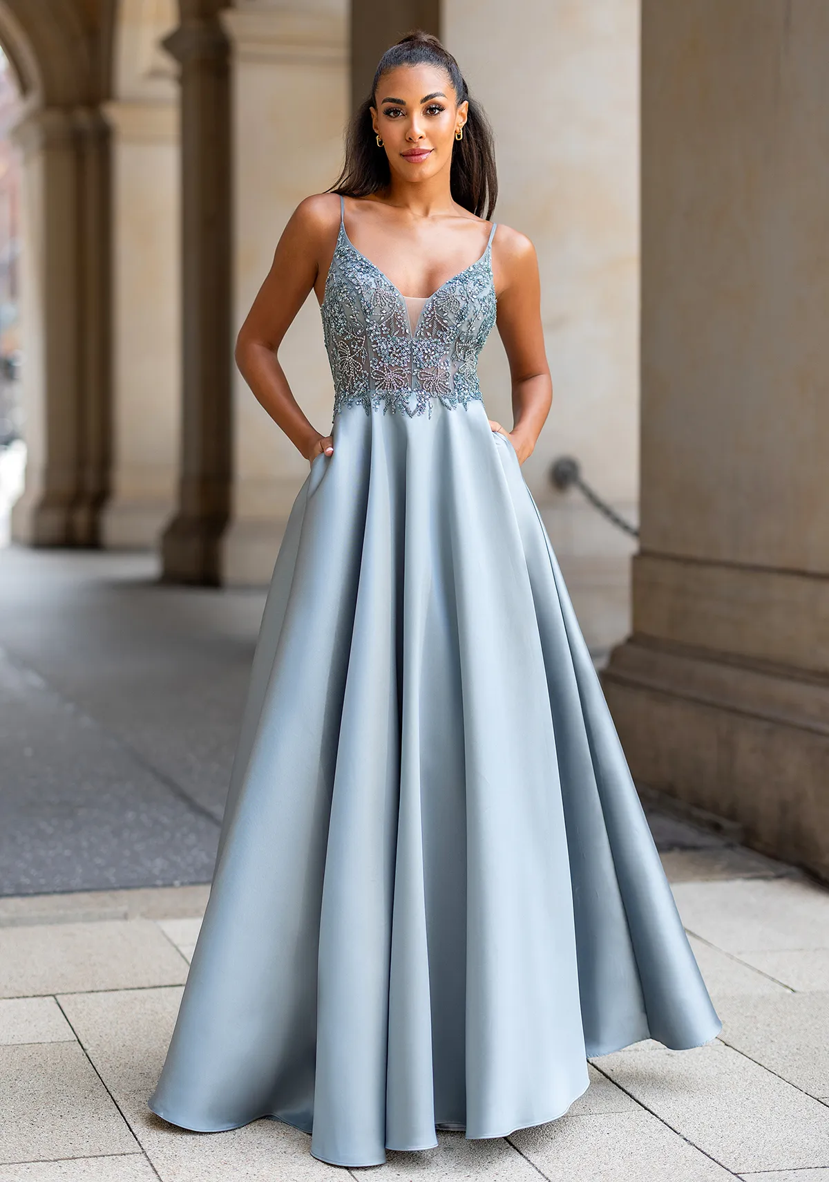 Ballkleid silberfarben aus Mikadostoff und mit transparentem Oberteil traumhaft verziert, Vorderansicht Frau in einem silberfarbenen Ballkleid aus Mikadostoff und mit transparentem Oberteil traumhaft verziert, Vorderansicht