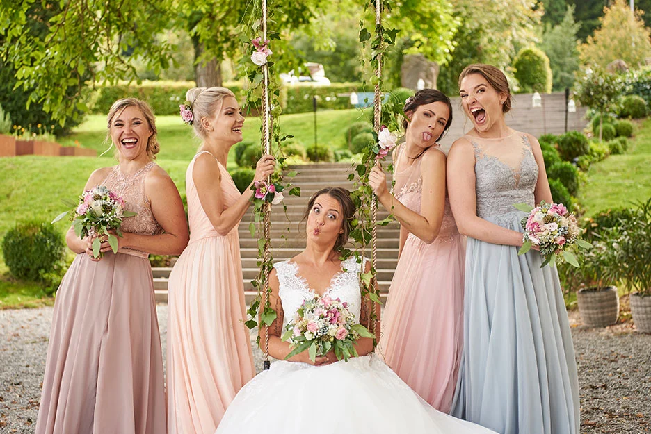 4 Brautjungfern in Brautjungfernkleider zusammen mit der Braut, die Braut uf der Schaukel sitzend, Brautjungfern links und rechts