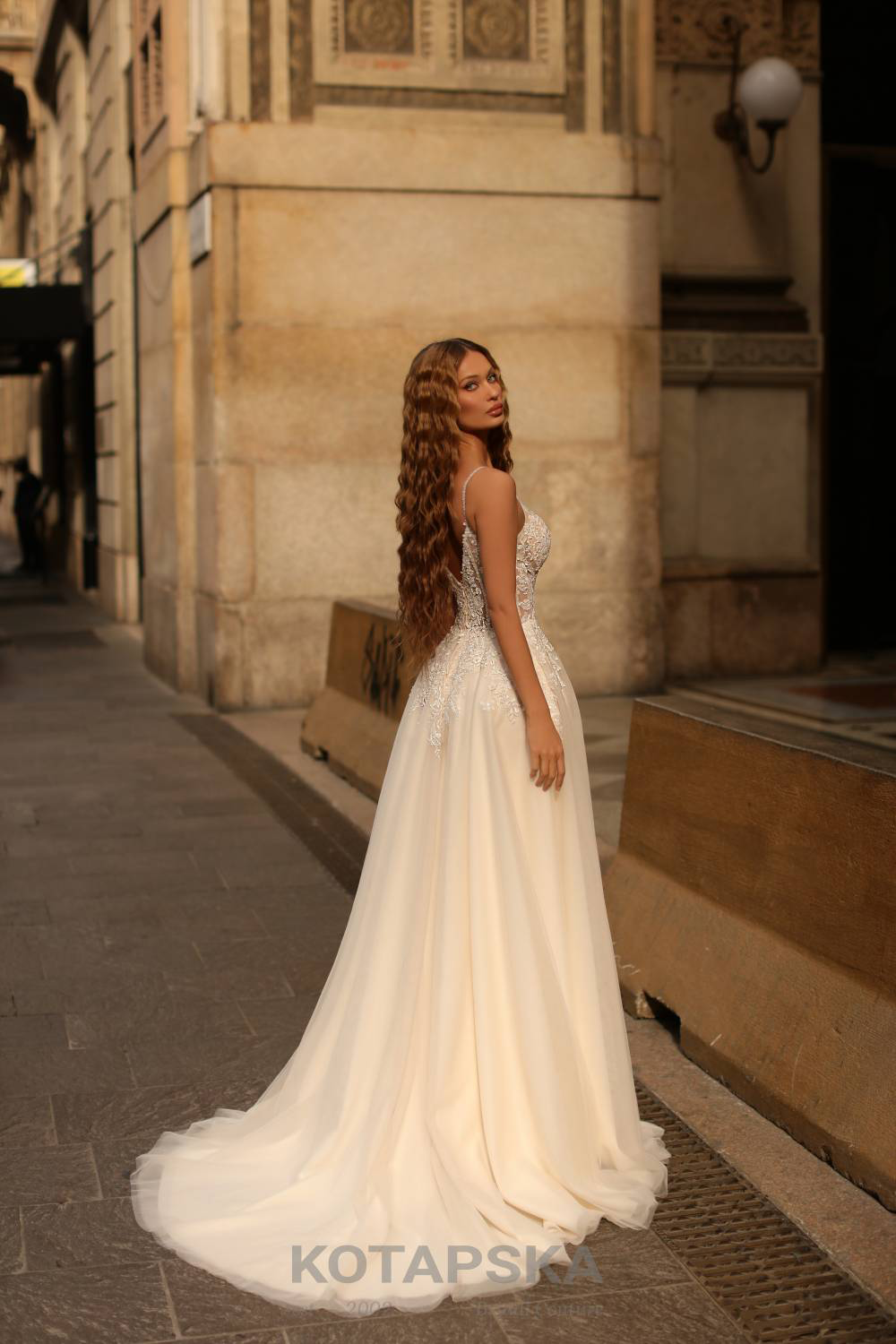 Frau in einem romantischen Hochzeitskleid, Corsage und Rock mit bestickter Spitze verziert, Rückenansicht