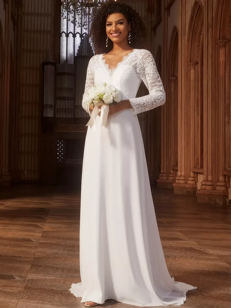 Schwangere Braut in elegantem weissem Brautkleid mit langen Spitzenärmeln und V Ausschnitt in stilvoller historischer Kulisse