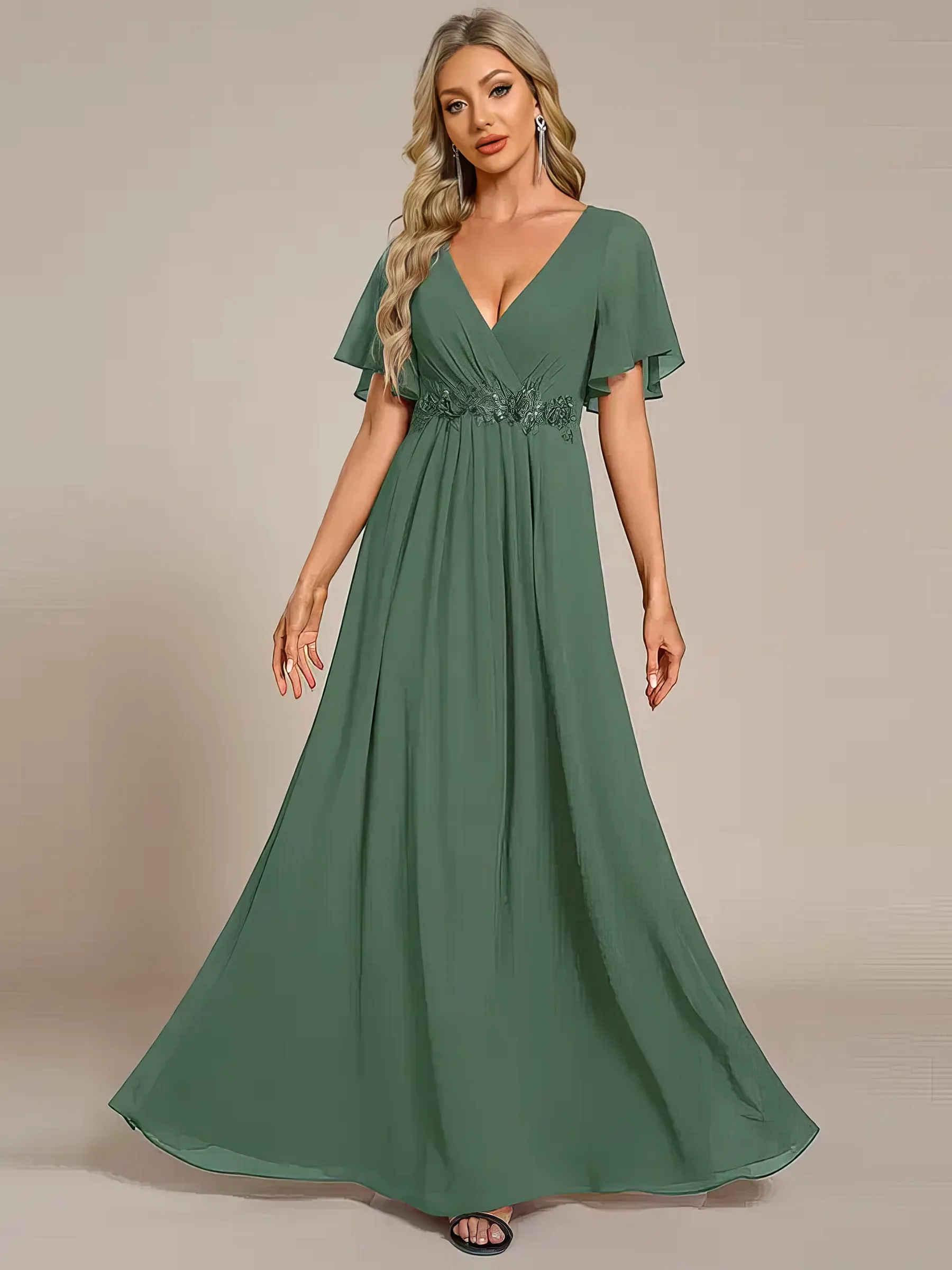 Langes Abendkleid in Eukalyptus-Grün aus Chiffon mit V-Ausschnitt, Fledermausärmeln und paillettenbestickten Blumenapplikationen an der Taille – elegant für Hochzeit, Gala oder als Brautjungfer.