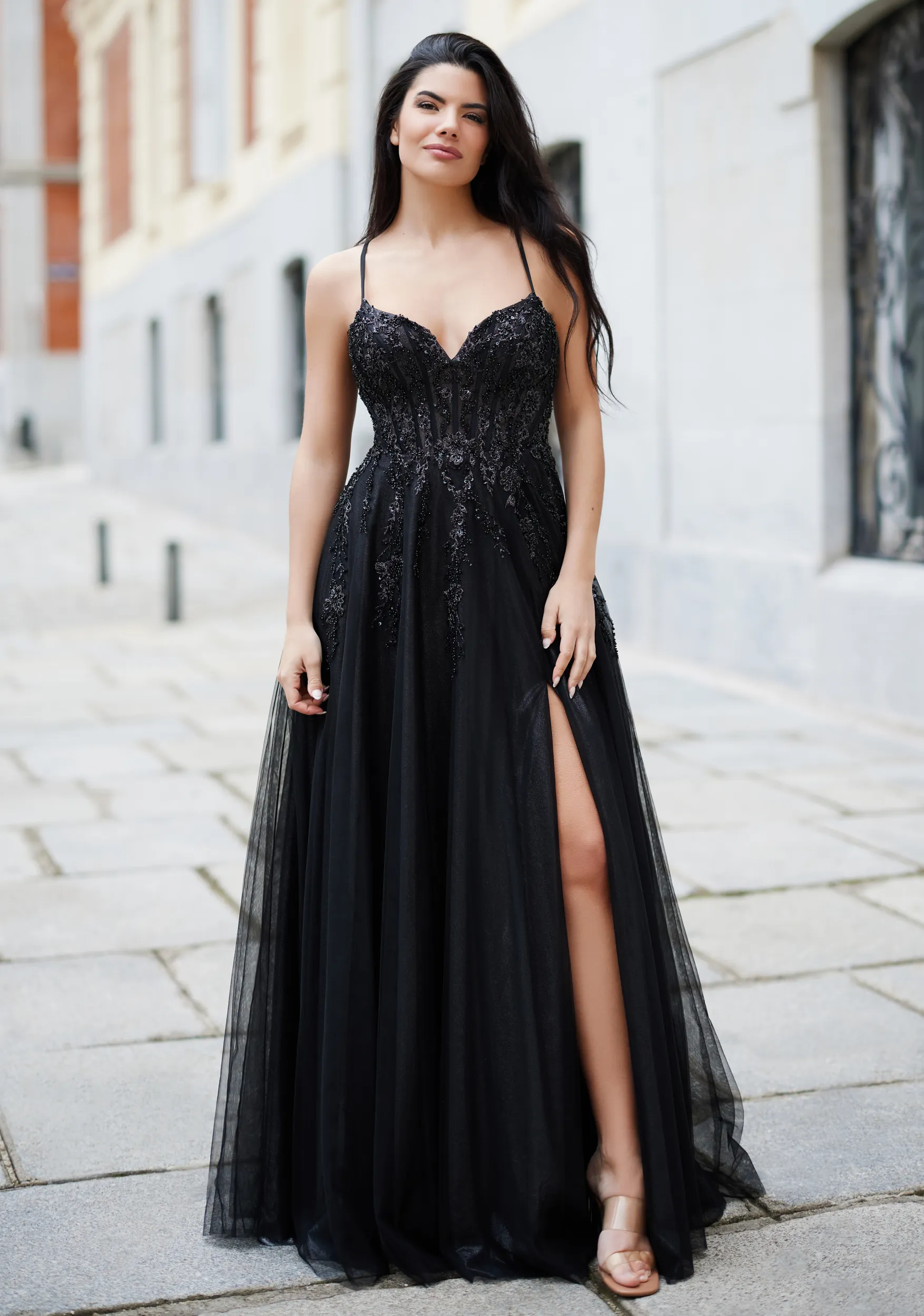 Frau in einem schwarzen Ballkleid mit Korsage und Beinschlitz, Vorderansicht