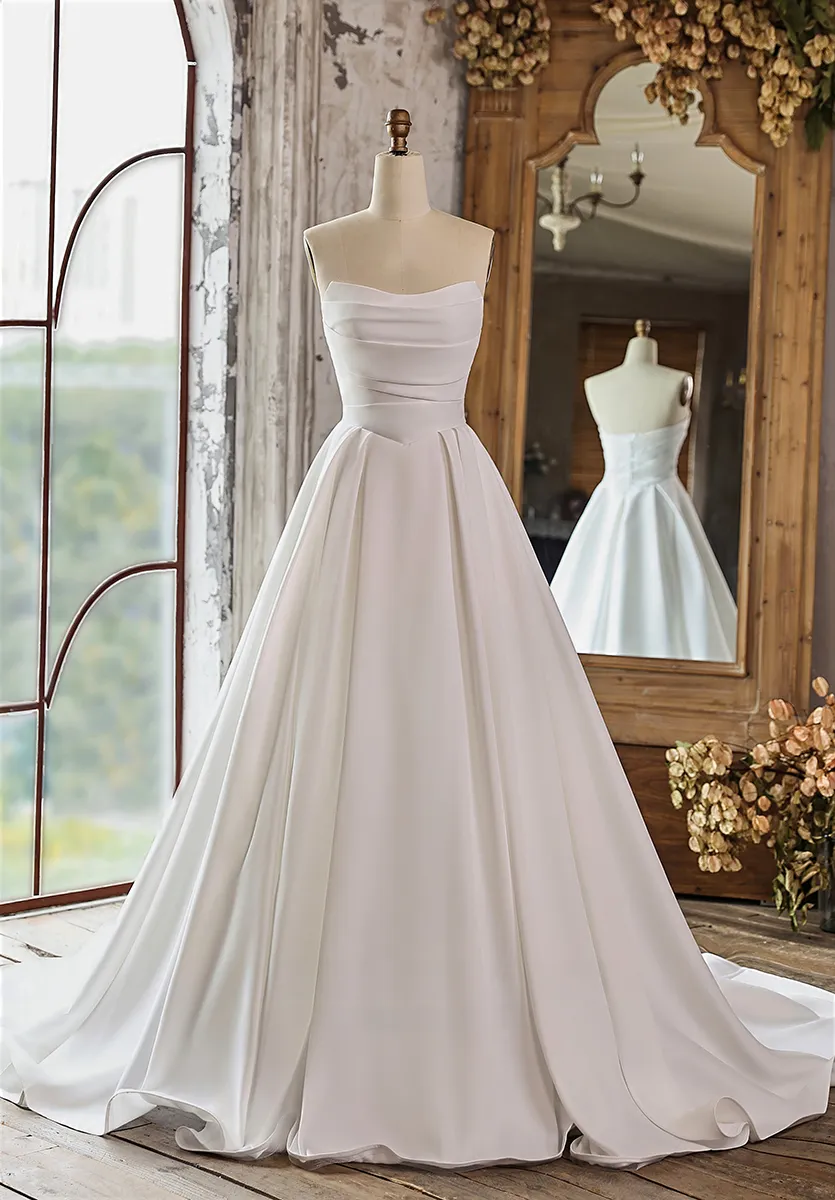 Minimalistisches Brautkleid aus mattem Satin in A-Linie mit trägerlosem geradem Ausschnitt und feinen Drapierungen am Oberteil – zeitloser Minimalismus-Trend Brautmode 2026 Zürich