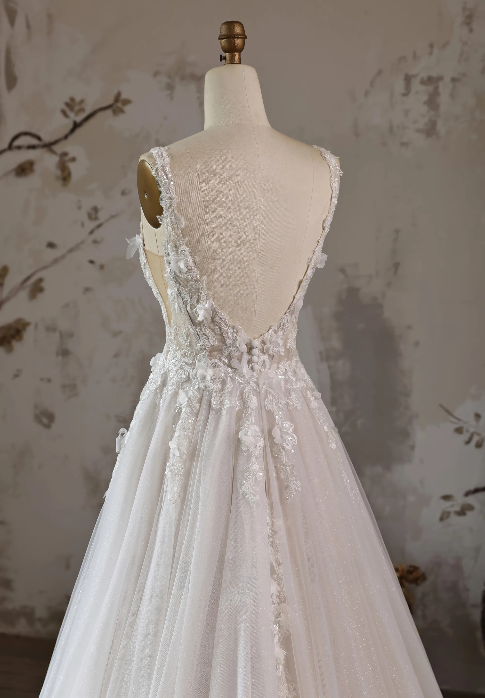 Romantisches Hochzeitskleid mit Korsage und 3D-Blüten an einer Schneiderpuppe, Close-up Rückenansicht