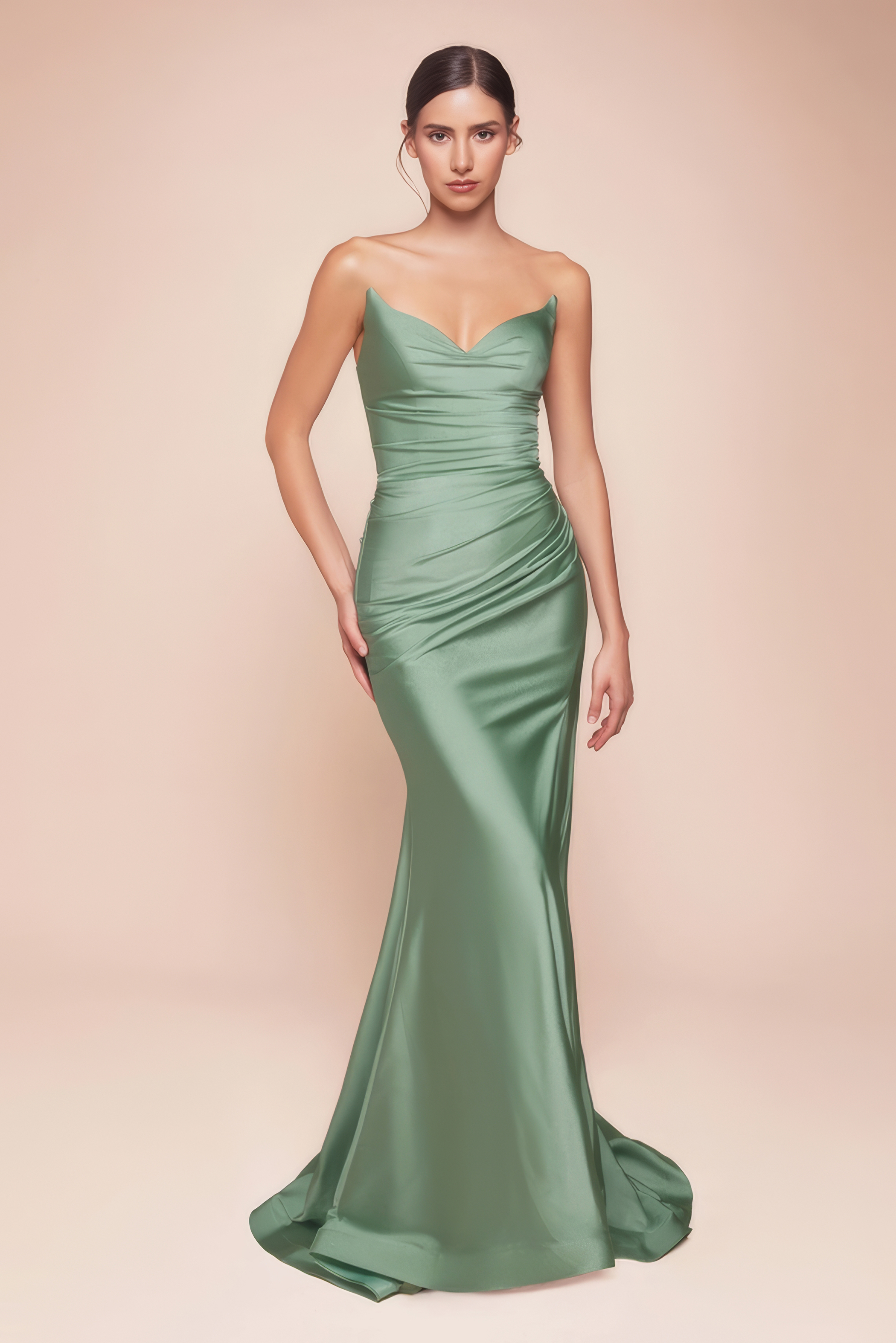 Frau in einem figurbetonten Abendkleid in der Farbe Dunkelsalbei mit hohem Beinschlitz