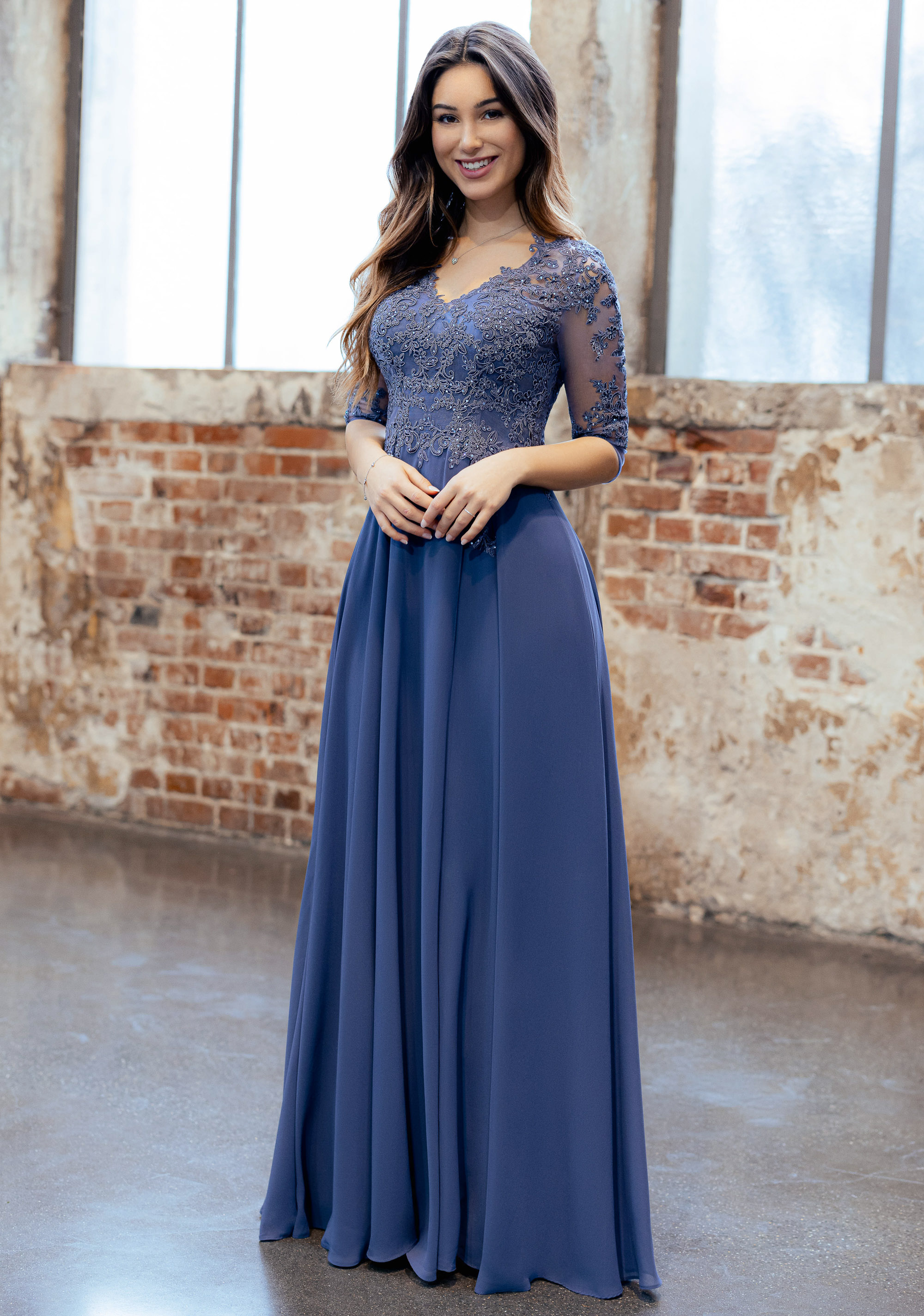 Chiffon Abendkleid mit Ärmel in blau Frau in einem langen blauen Abendklei mit 3/4-Ärmeln und Spitzenoberteil