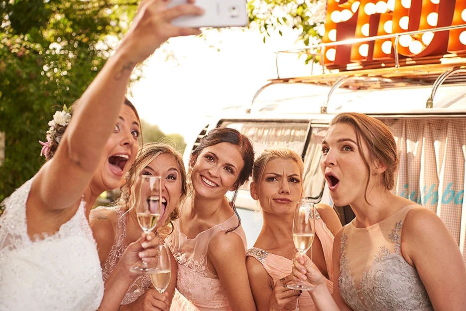 4 Brautjungfern in Brautjungfernkleider zusammen mit der Braut, die Braut ein Selfie am schiessen und alle am lachen