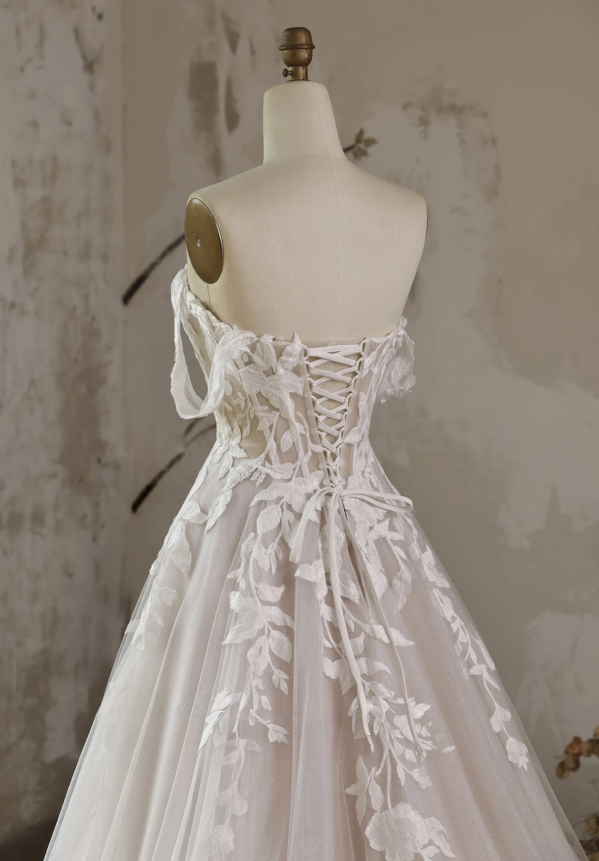 Romantisches Hochzeitskleid mit grossen Spitzen-Applikationen und mit Rückenschnürung an einer Schneiderpuppe, Rücken Close-up