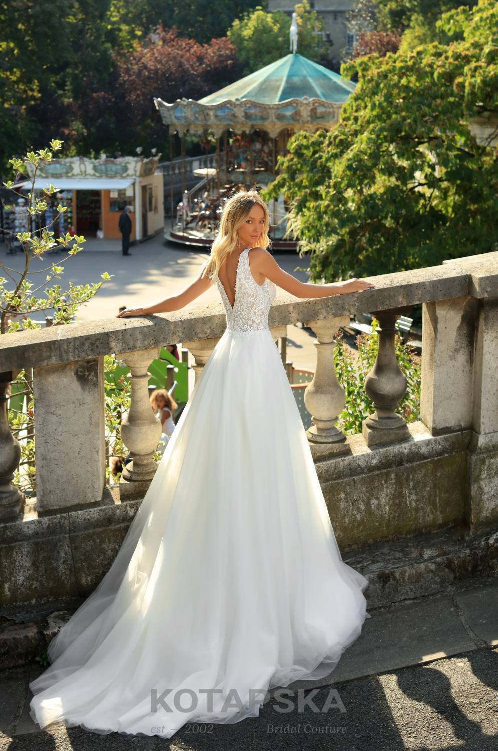 Braut im schlichten Hochzeitskleid, Oberteil mit tiefem V-Ausschnitt und Spitze verziert, Rückenansicht