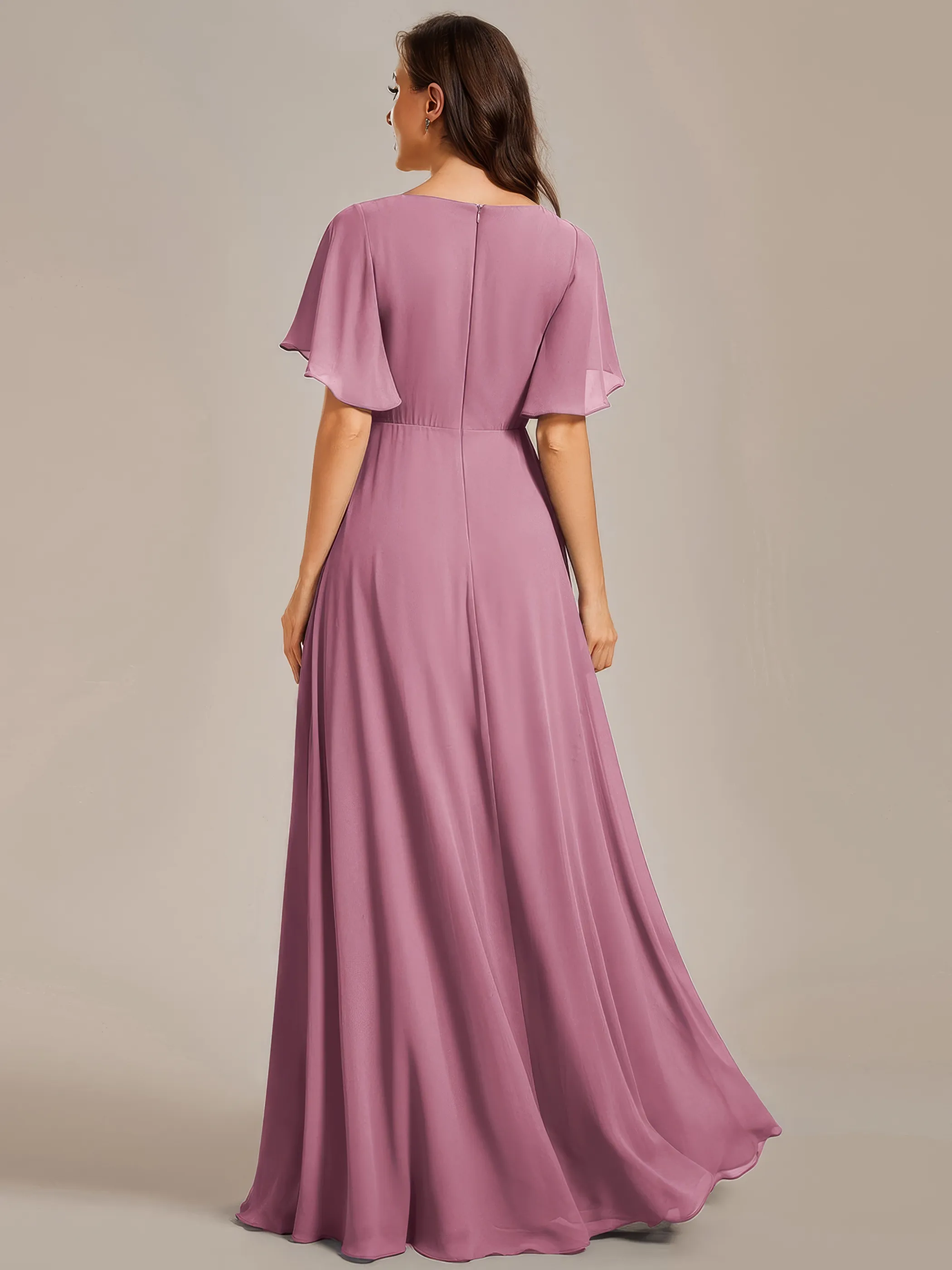 Frau in einem Chiffon-Abendkleid mit Fledermausärmel und Verzierungen Orchideenfarben, Rückenansicht