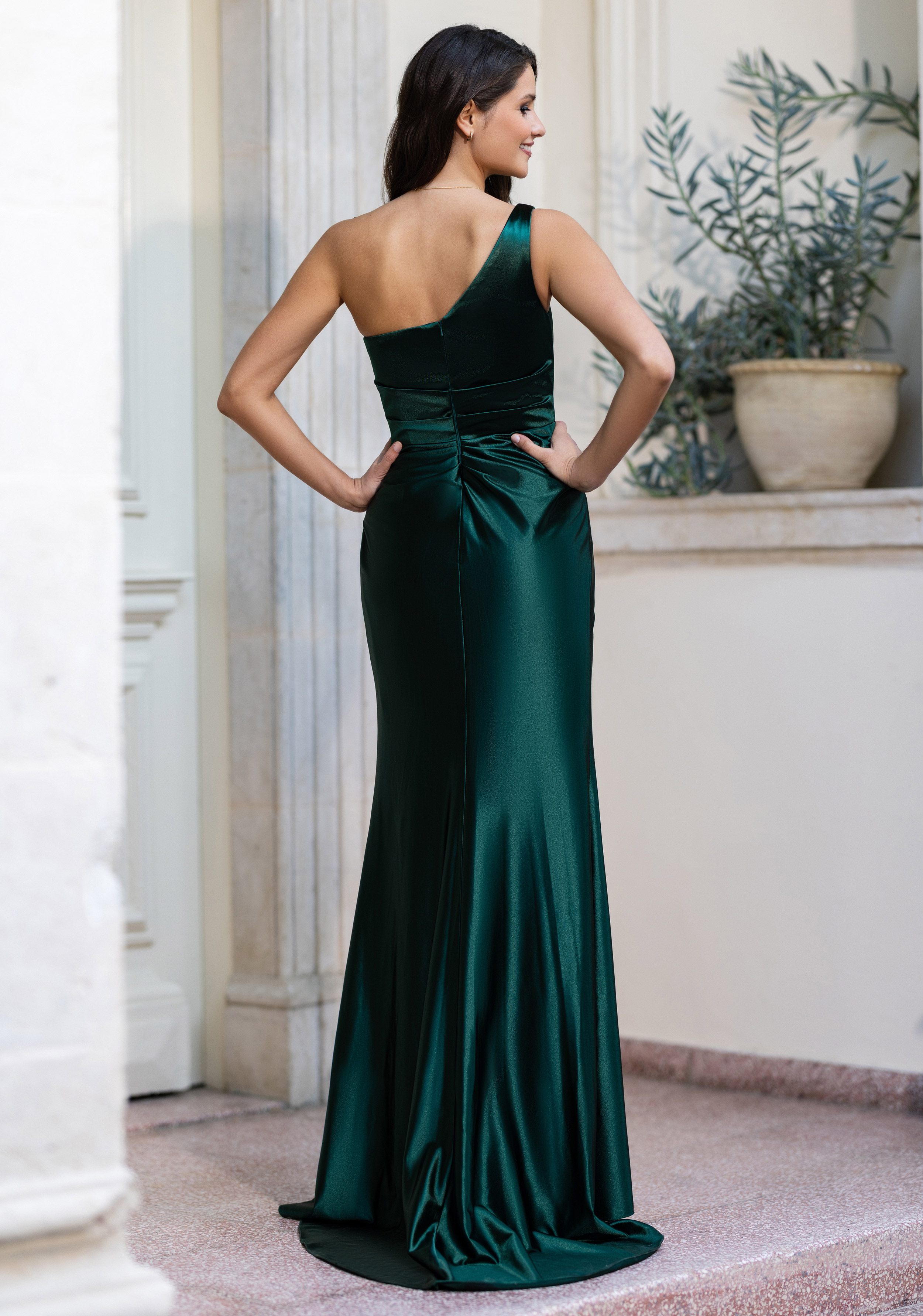 Frau in einem eng anliegenden Abendkleid, One-Shoulder, aus grünem Satin