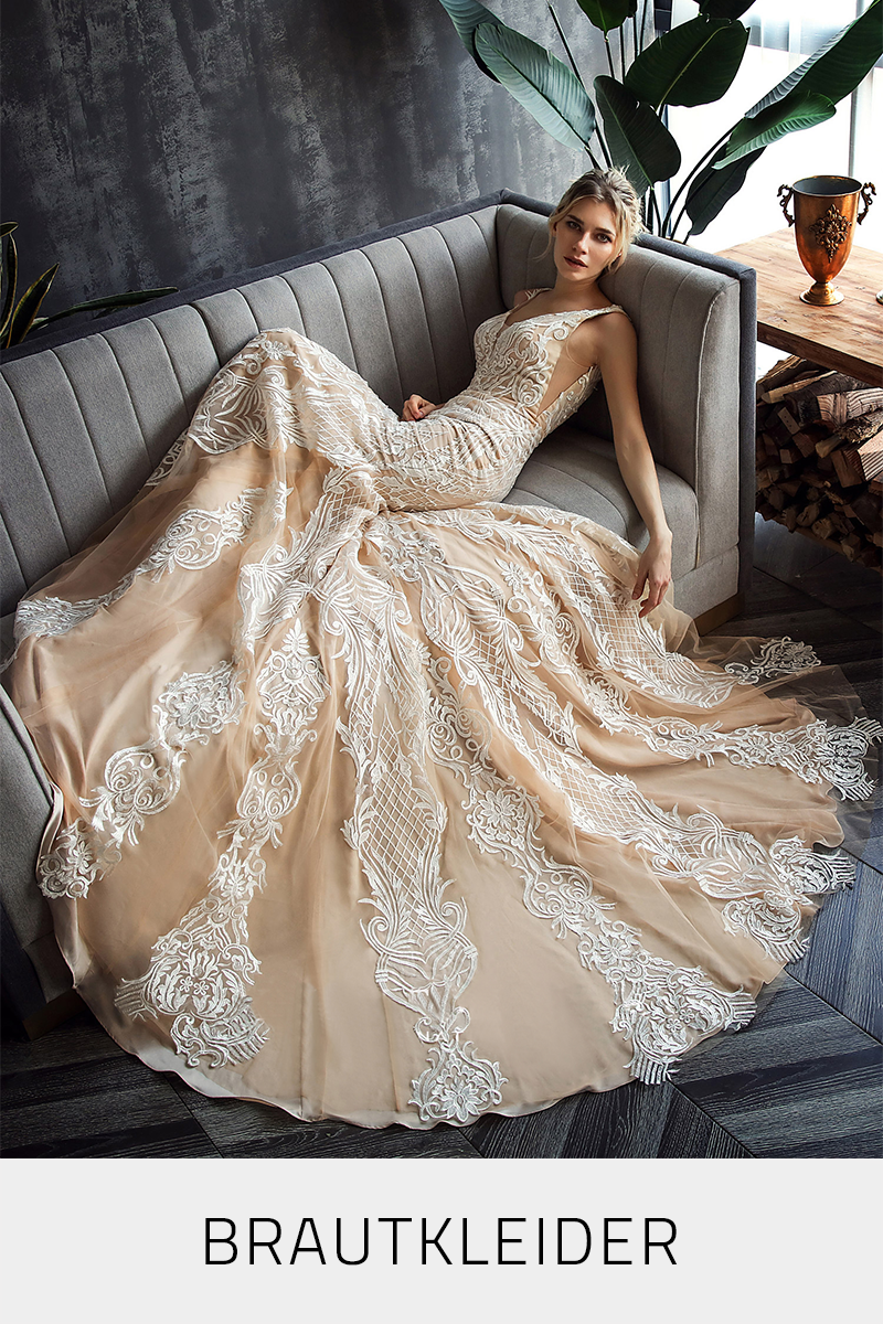 Braut liegt im Spitzen-Brautkleid auf dem Sofa, die grosse Brautkleid-Schleppe schön drappiert