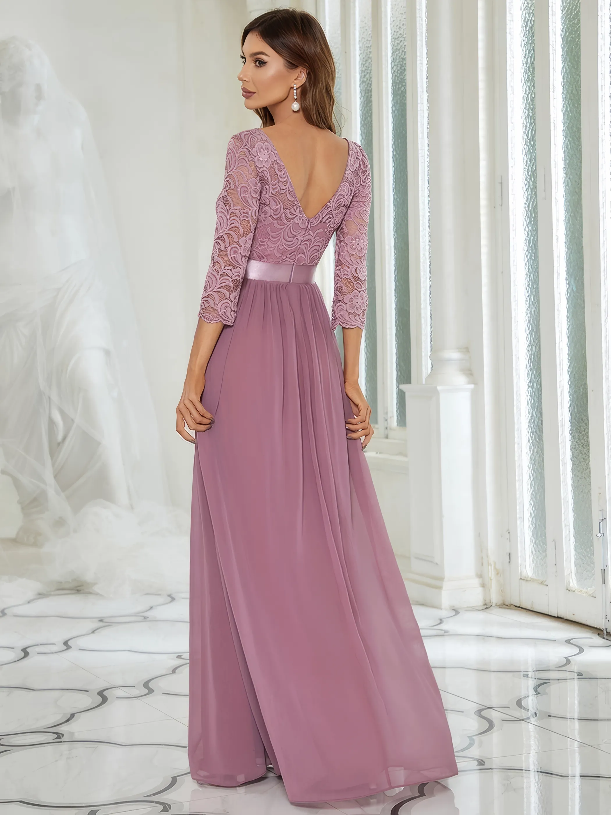 Frau in einem Abendkleid Altrosa aus Chiffon und mit Spitzenoberteil und langen Ärmeln, Rückenansicht