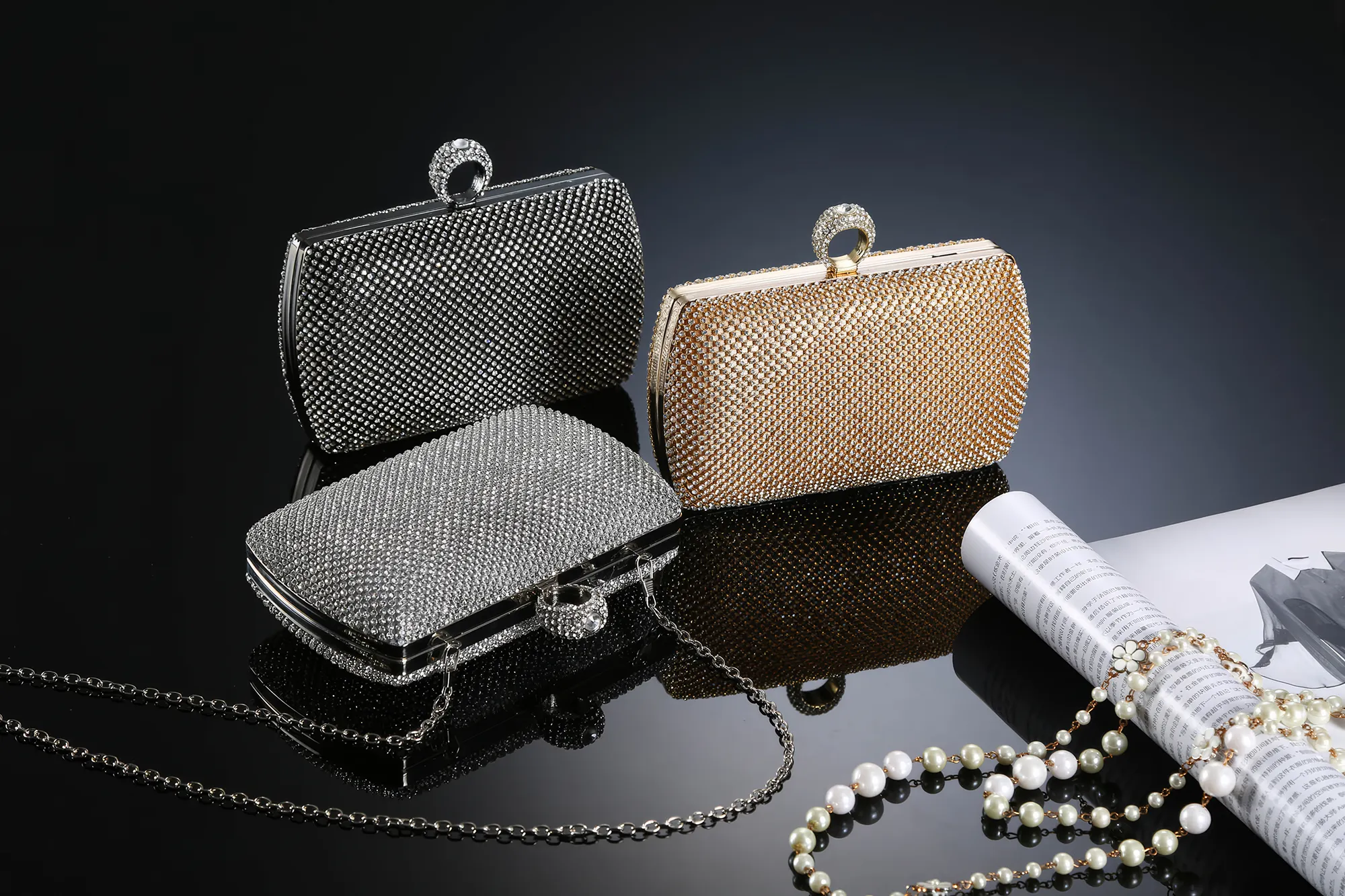 Drei Strass-Handtaschen in den Farben Schwarz, Gold und Silber