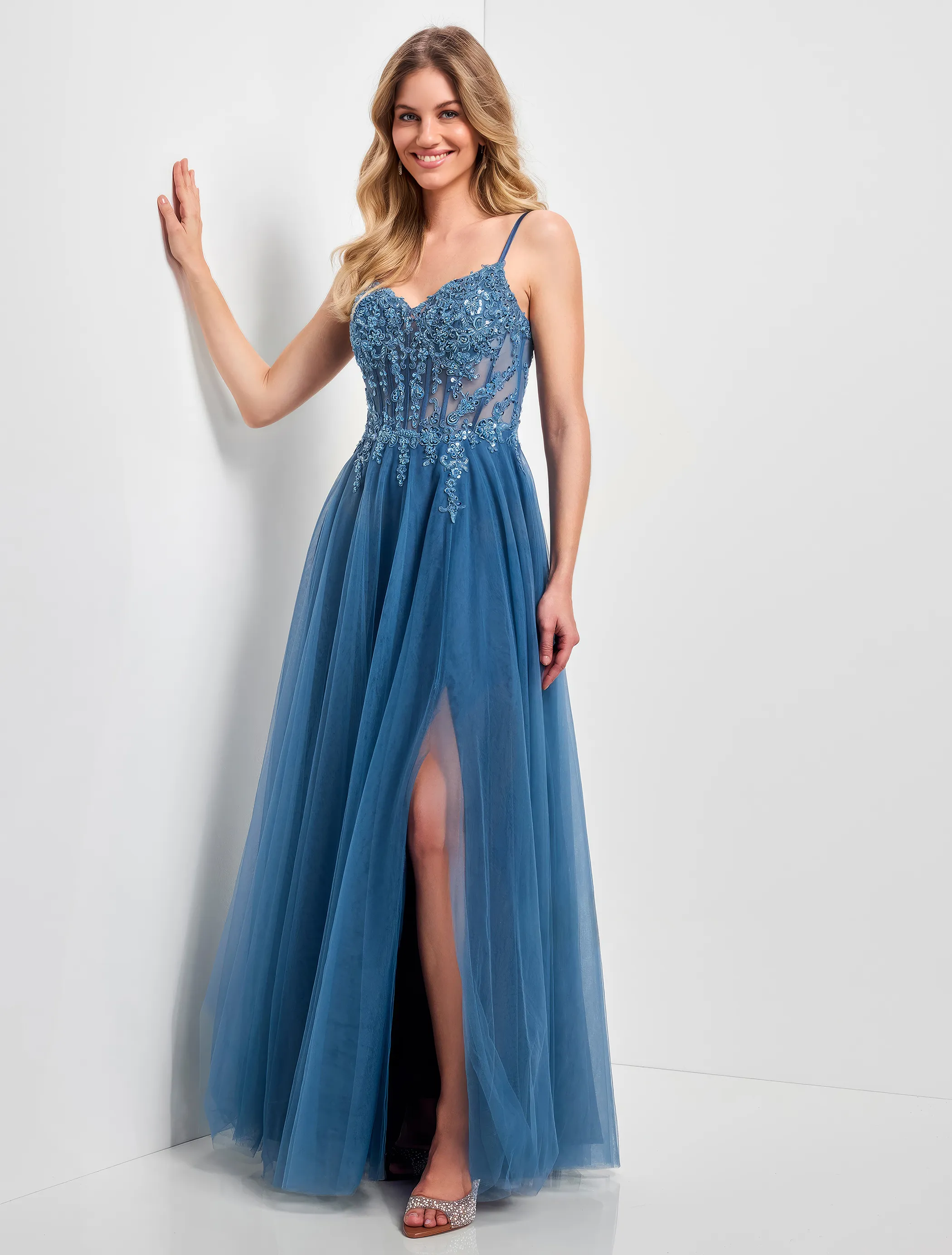 Frau in einem rauchblauen Abendkleid/Ballkleid mit verziertem Corsagenoberteil und Beinschlitz