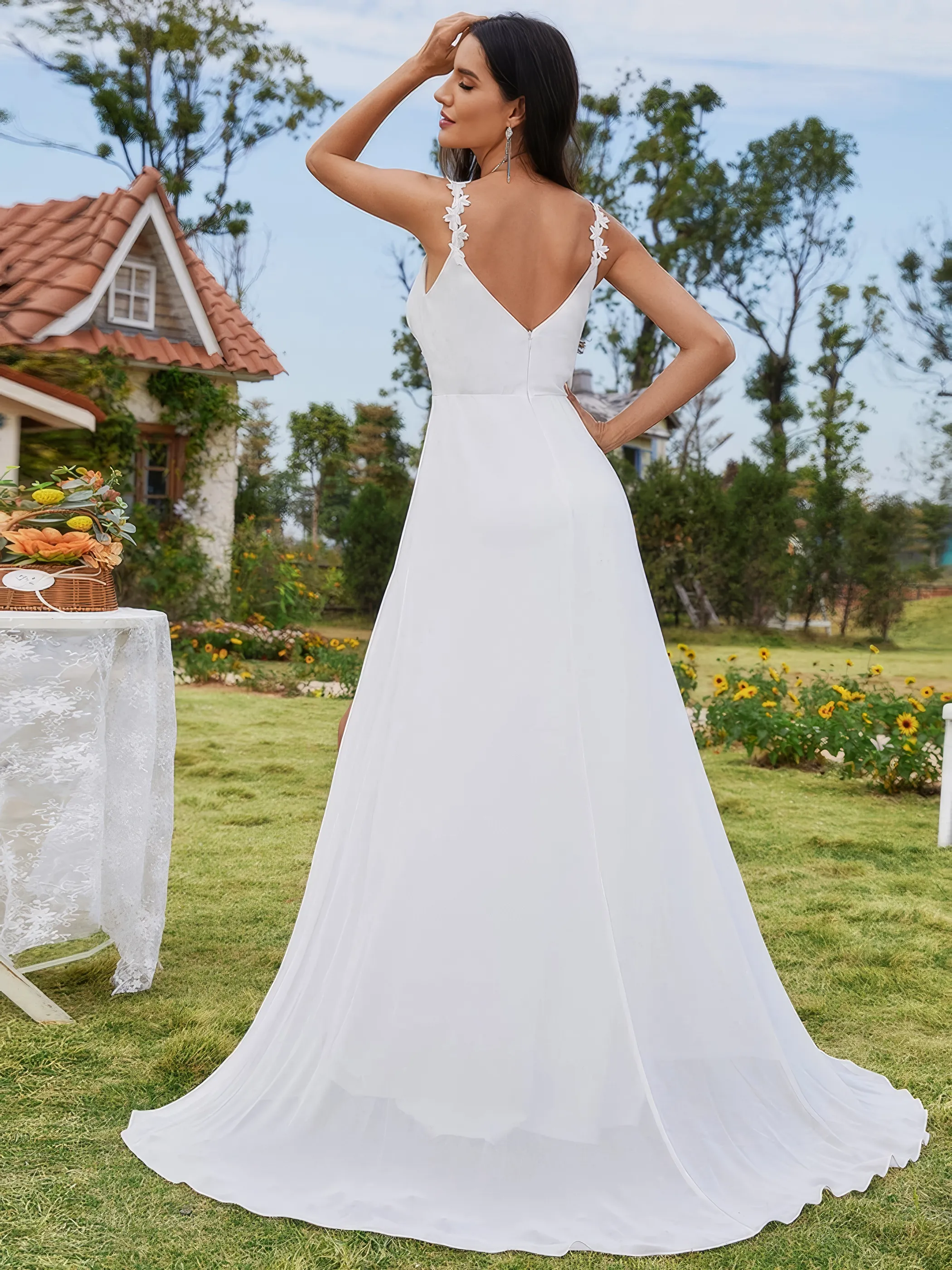 Braut in einem Chiffon-Brautkleid mit Beinschlitz und Spitzen verziert, Rückenasicht