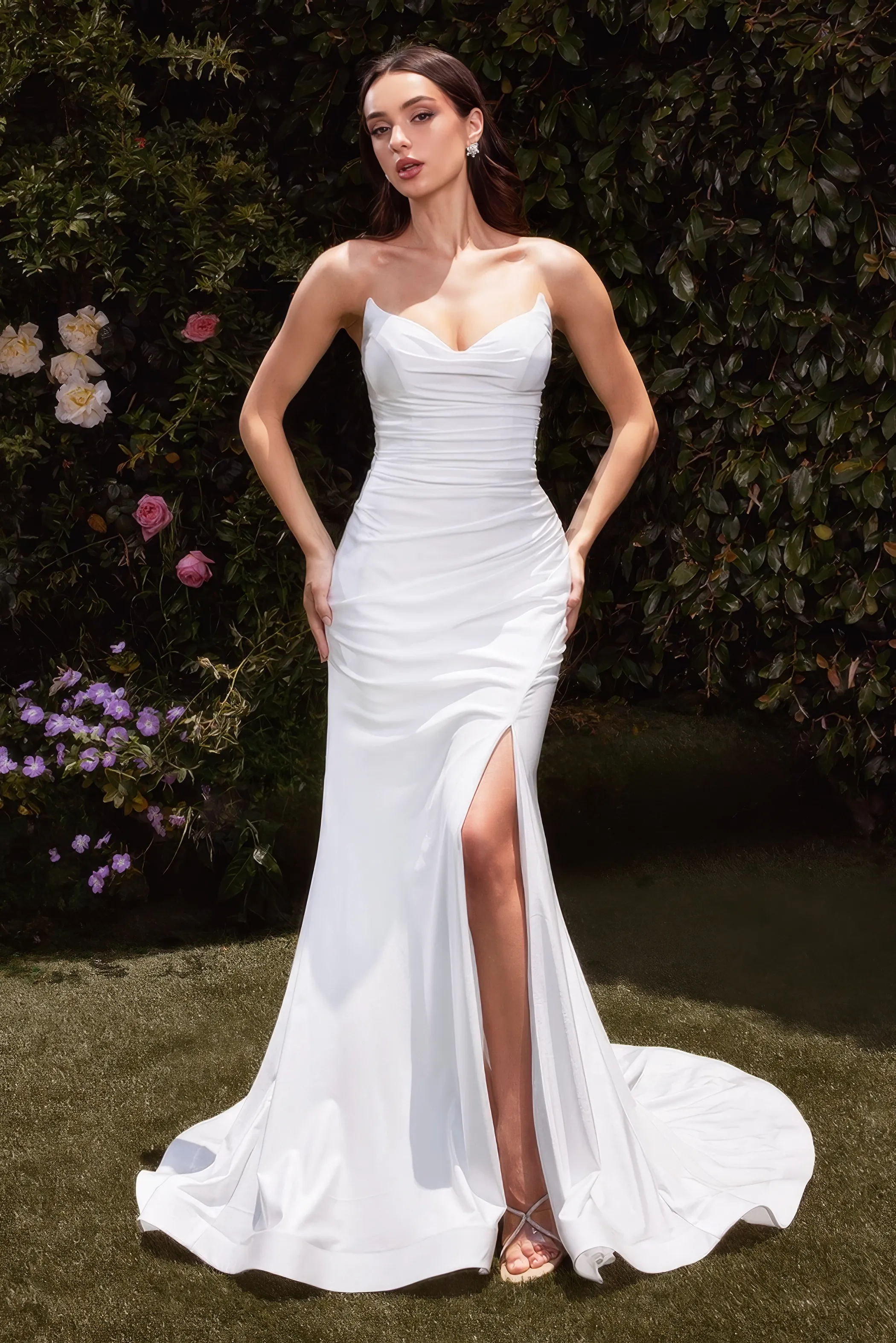 Braut in einem figurbetonten, elastischen Hochzeitskleid mit Beinschlitz