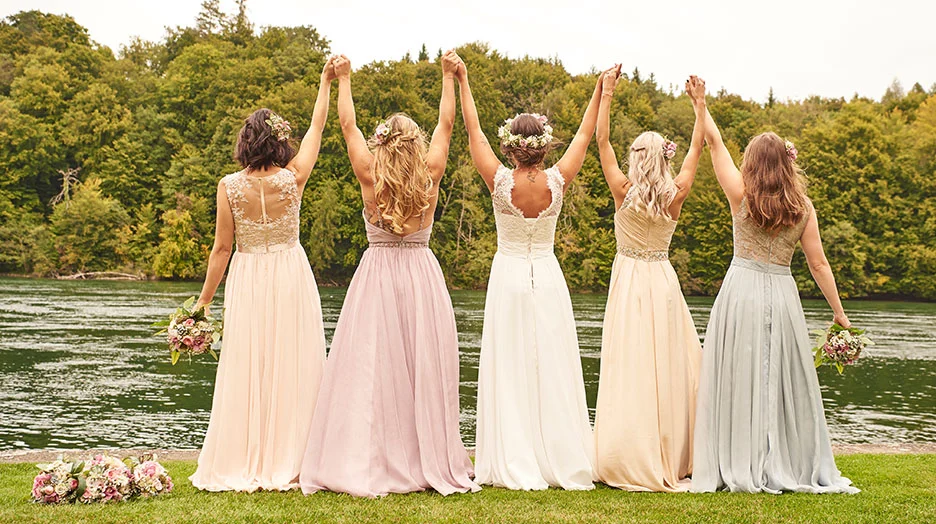 4 Brautjungfern und die Braut am Fluss 4 Brautjungfern in Brautjungfernkleider zusammen mit der Braut am Fluss stehend, Rückenansicht