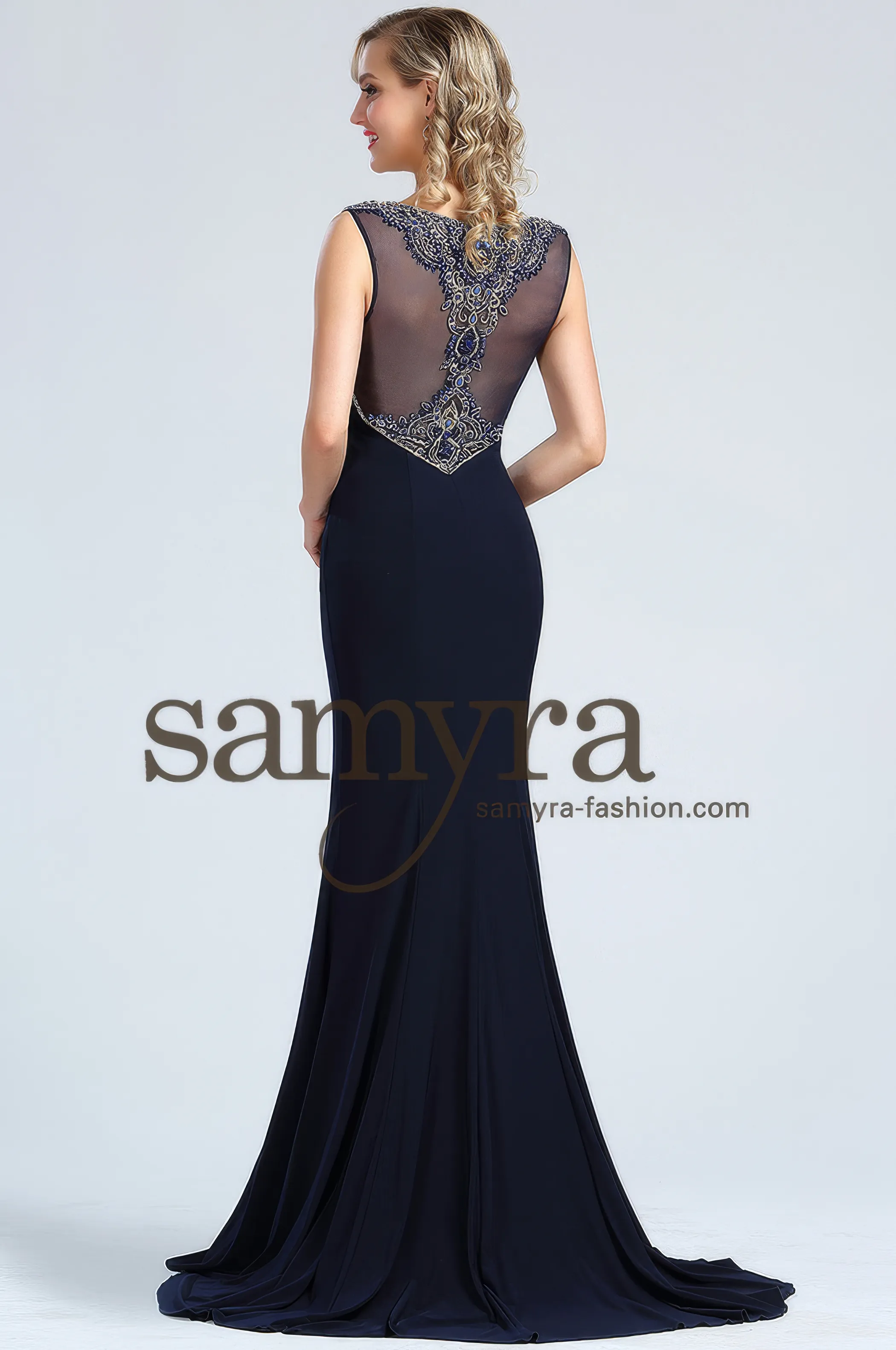 Frau in einem figurbetonten Abendkleid aus elastischem Material und mit Verzierungen, Rückenansicht