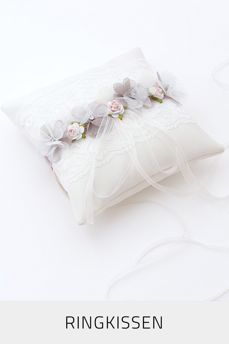 Zur Kategorie Ringkissen Ein elfenbeinfarbenes Ringkissen mit Stoffblumen-Verzierungen