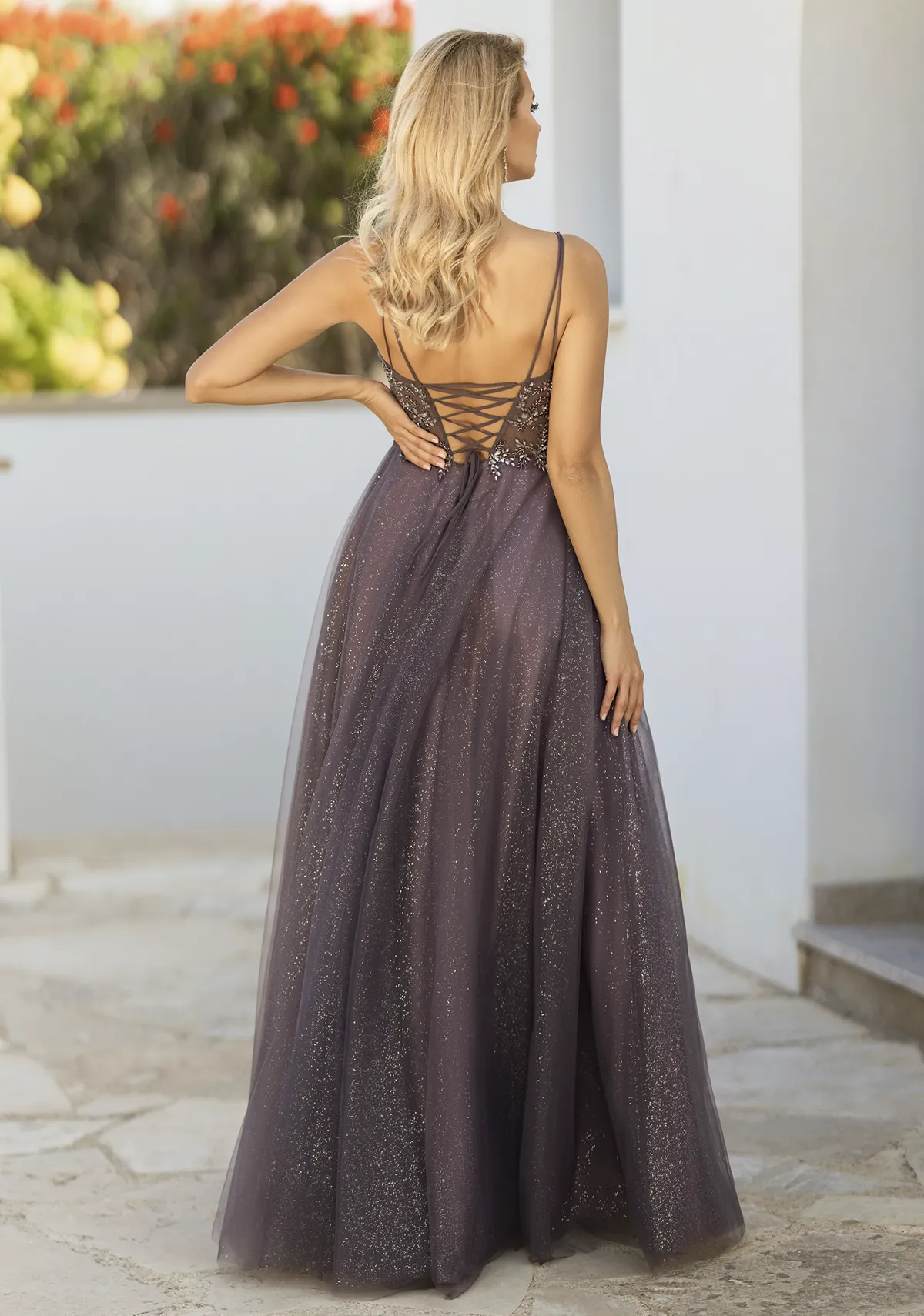 Blonde Frau in einem Ballkleid aus Glitzerstoff und mit Rückenschnürung pflaumenfarben, Rückenansicht