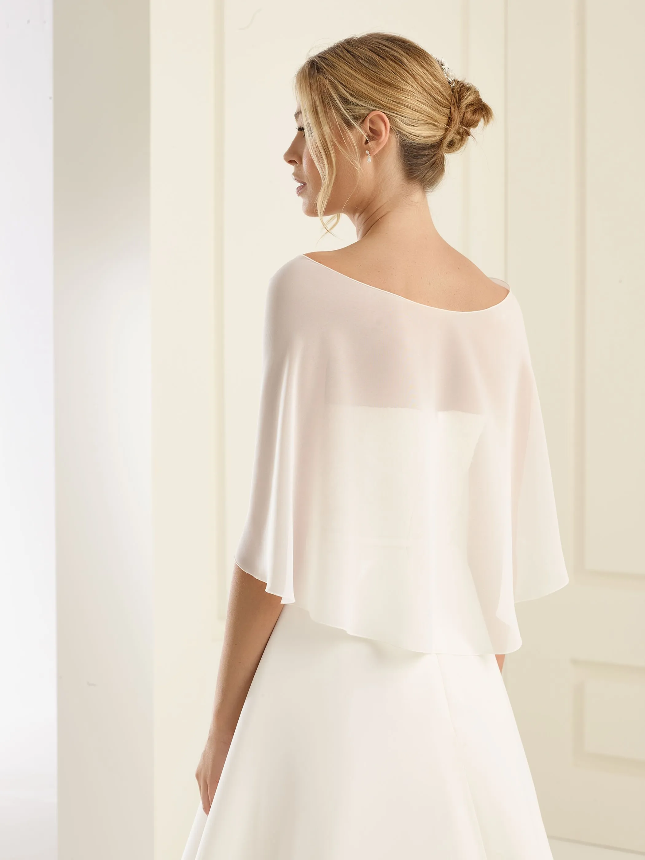 Brautstola aus Chiffon in der Farbe puderrosa Braut mit einem Chiffon-Schal in der Farbe Puderrosa, von hinten fotografiert