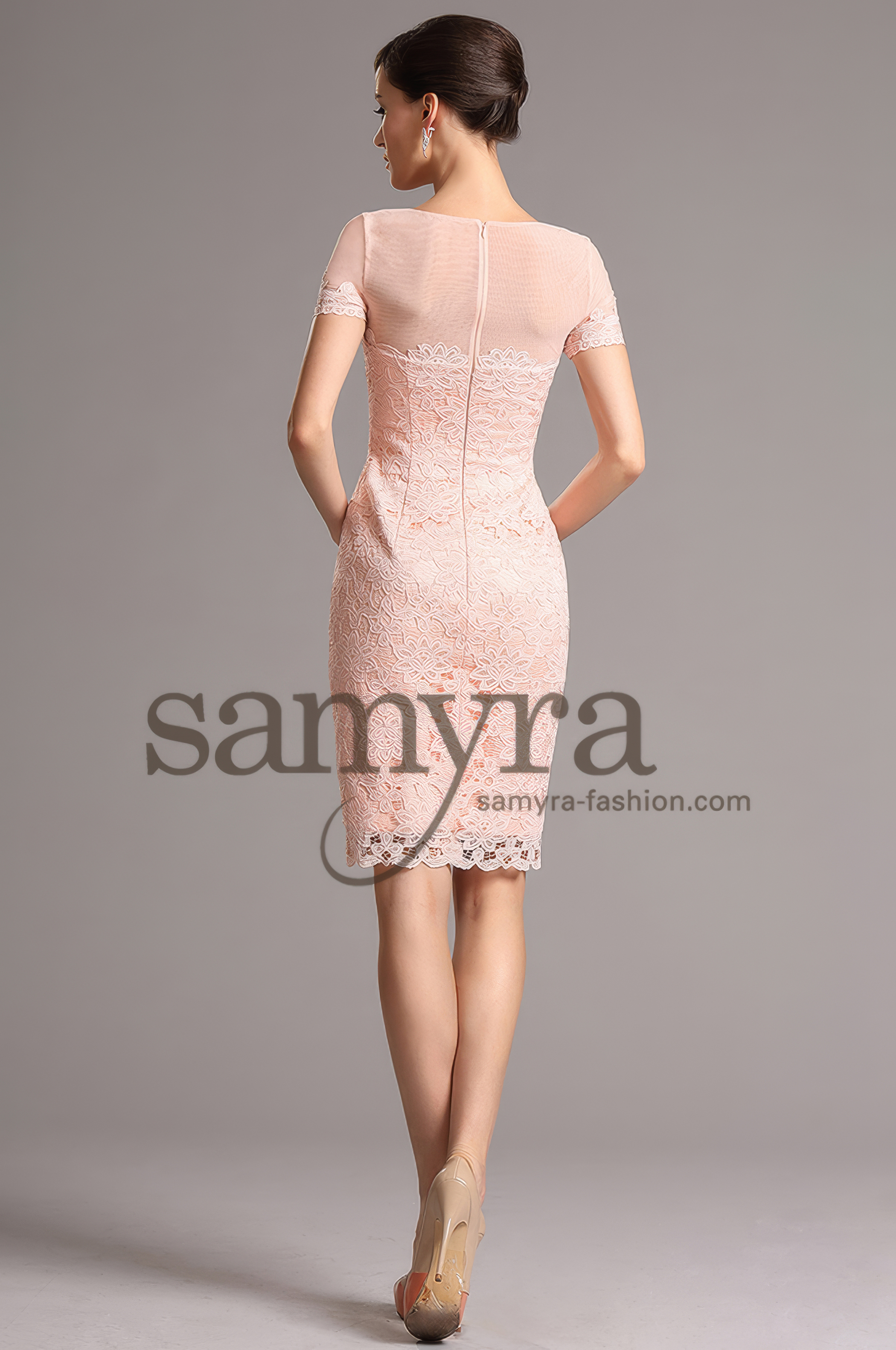 Frau in einem Spitzen-Cocktailkleid rosa mit Rundhals, Rückenansicht